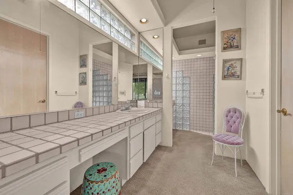 a bathroom with a sink shower and a mirror