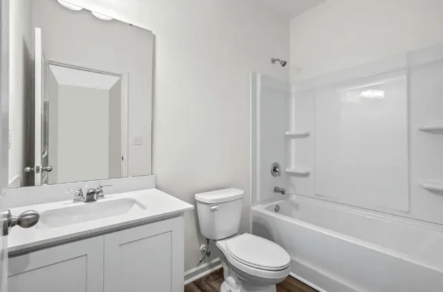 a bathroom with a sink toilet vanity and shower