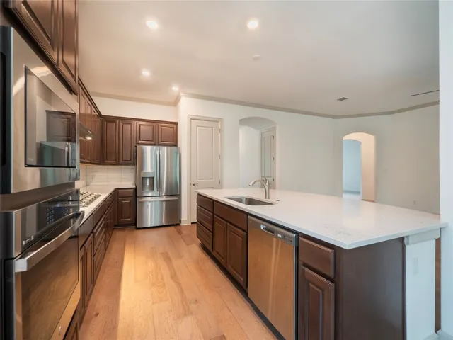 a kitchen with stainless steel appliances a sink and a refrigerator