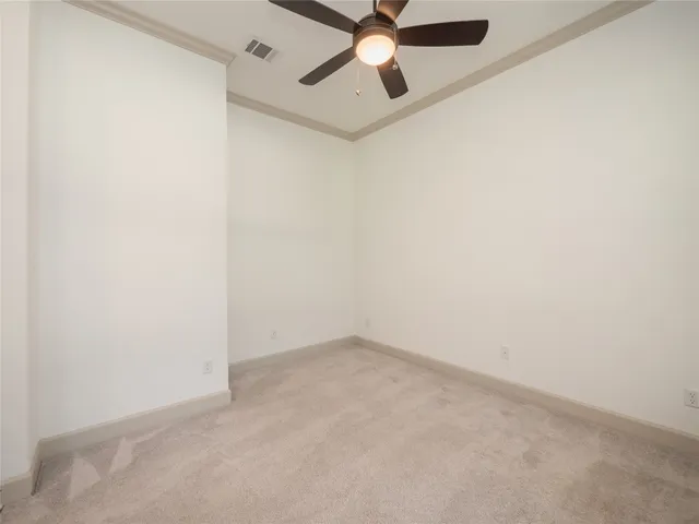 an empty room with a ceiling fan and a window