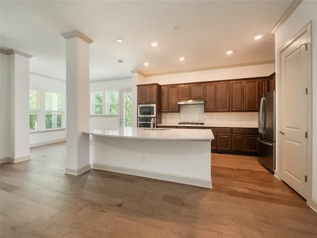 a kitchen with stainless steel appliances granite countertop a stove a sink and a refrigerator