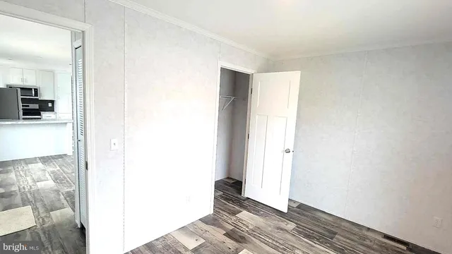 a view of a room with wooden floor and a bathroom