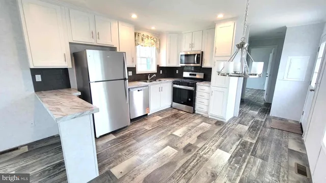 a kitchen with refrigerator and white cabinets
