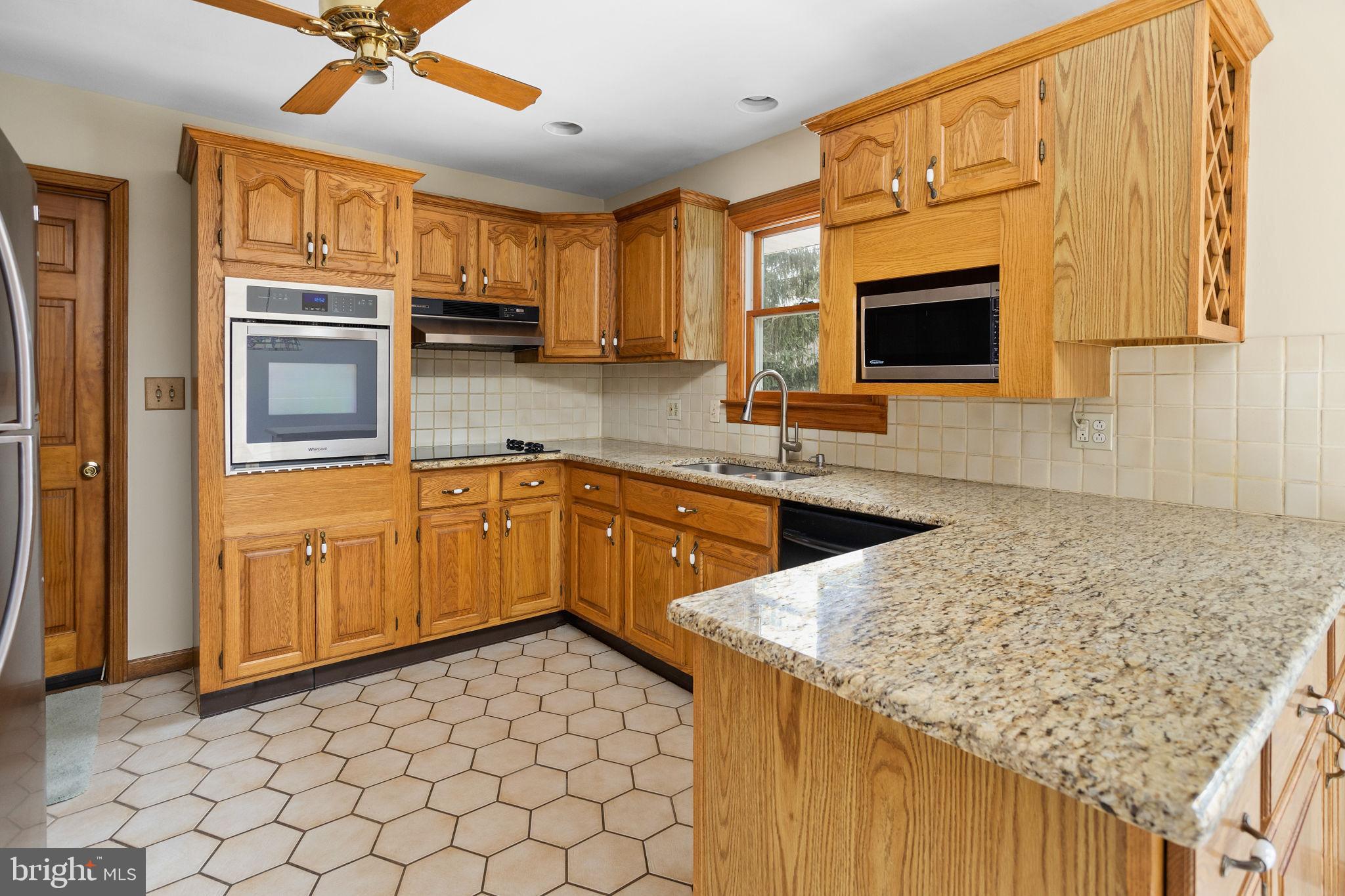 96 Bordentown Chesterfield Road Chesterfield, NJ 08515 - Photo 13 of 42 a kitchen with stainless steel appliances granite countertop a sink and dishwasher a stove with wooden cabinets