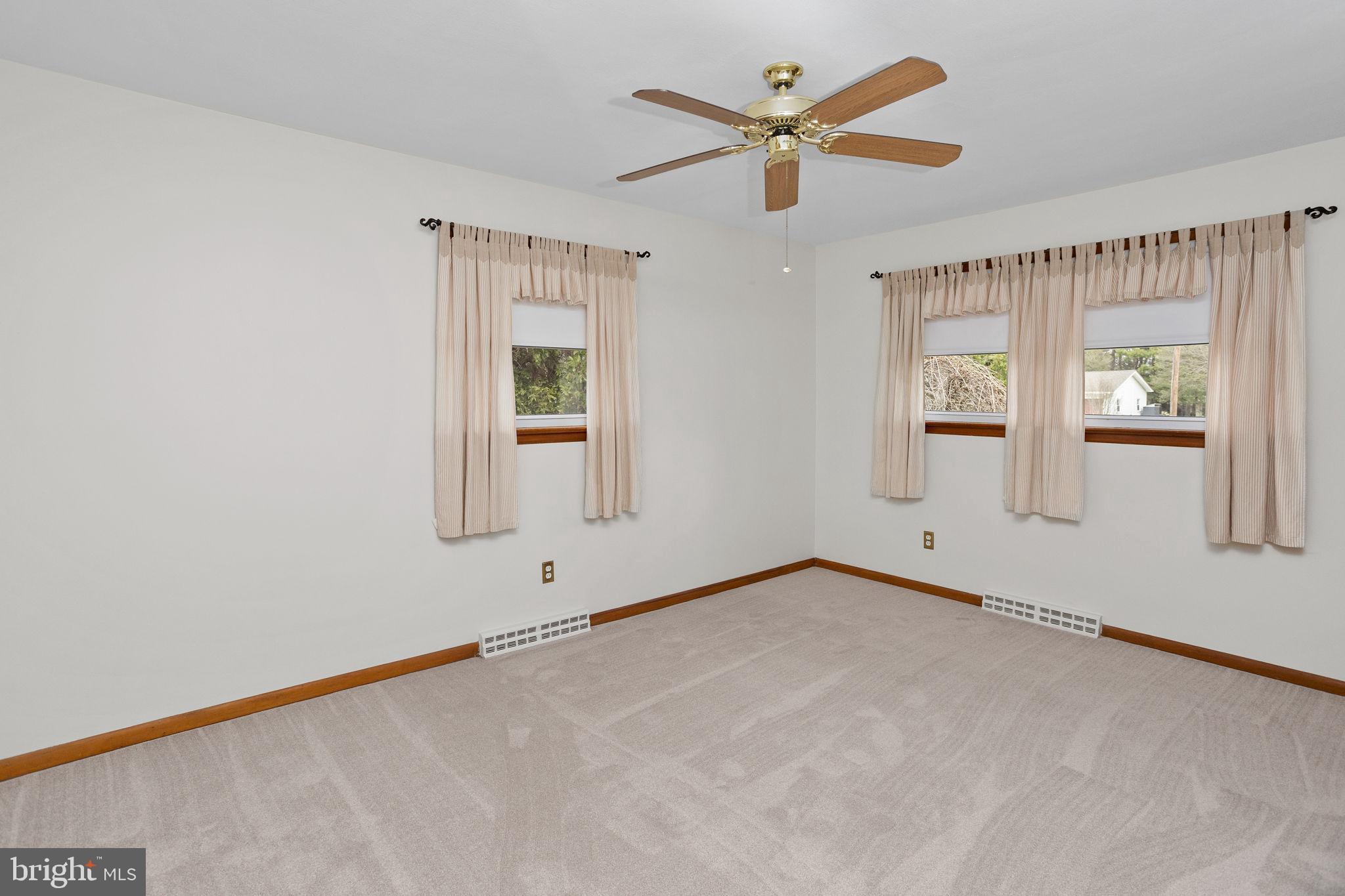 96 Bordentown Chesterfield Road Chesterfield, NJ 08515 - Photo 16 of 42 an empty room with chandelier fan and windows