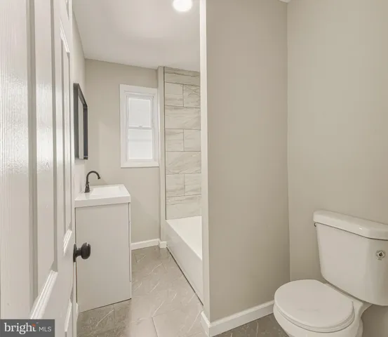 a white toilet sitting next to a bathroom sink