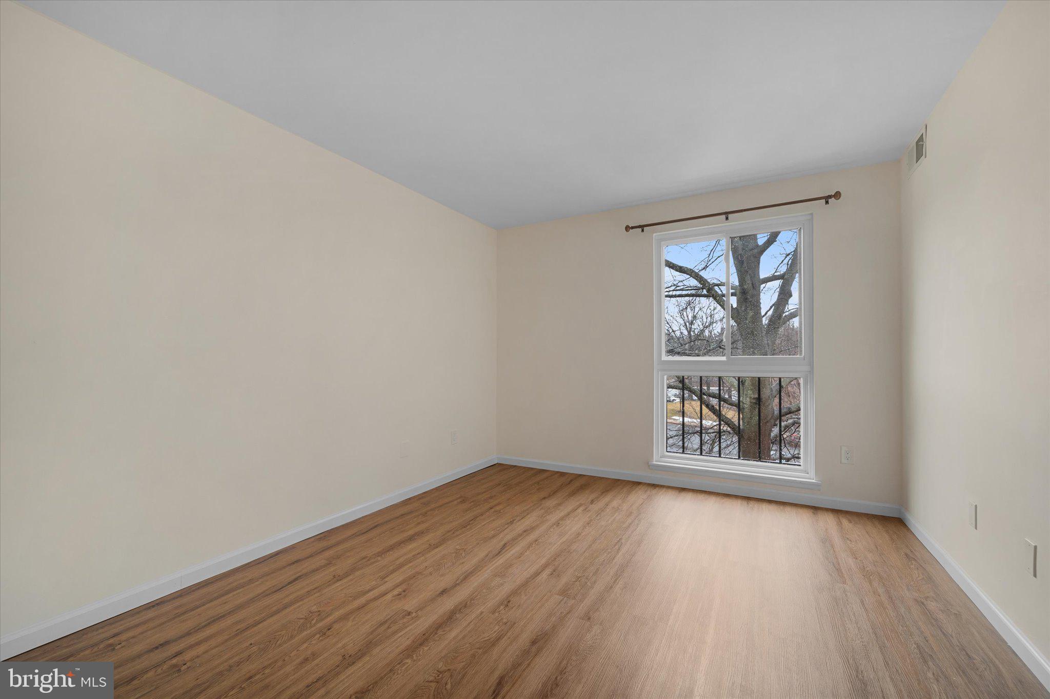 2073 Royal Fern Court, Unit 34/21B Reston, VA 20191 - Photo 18 of 25 an empty room with wooden floor and windows