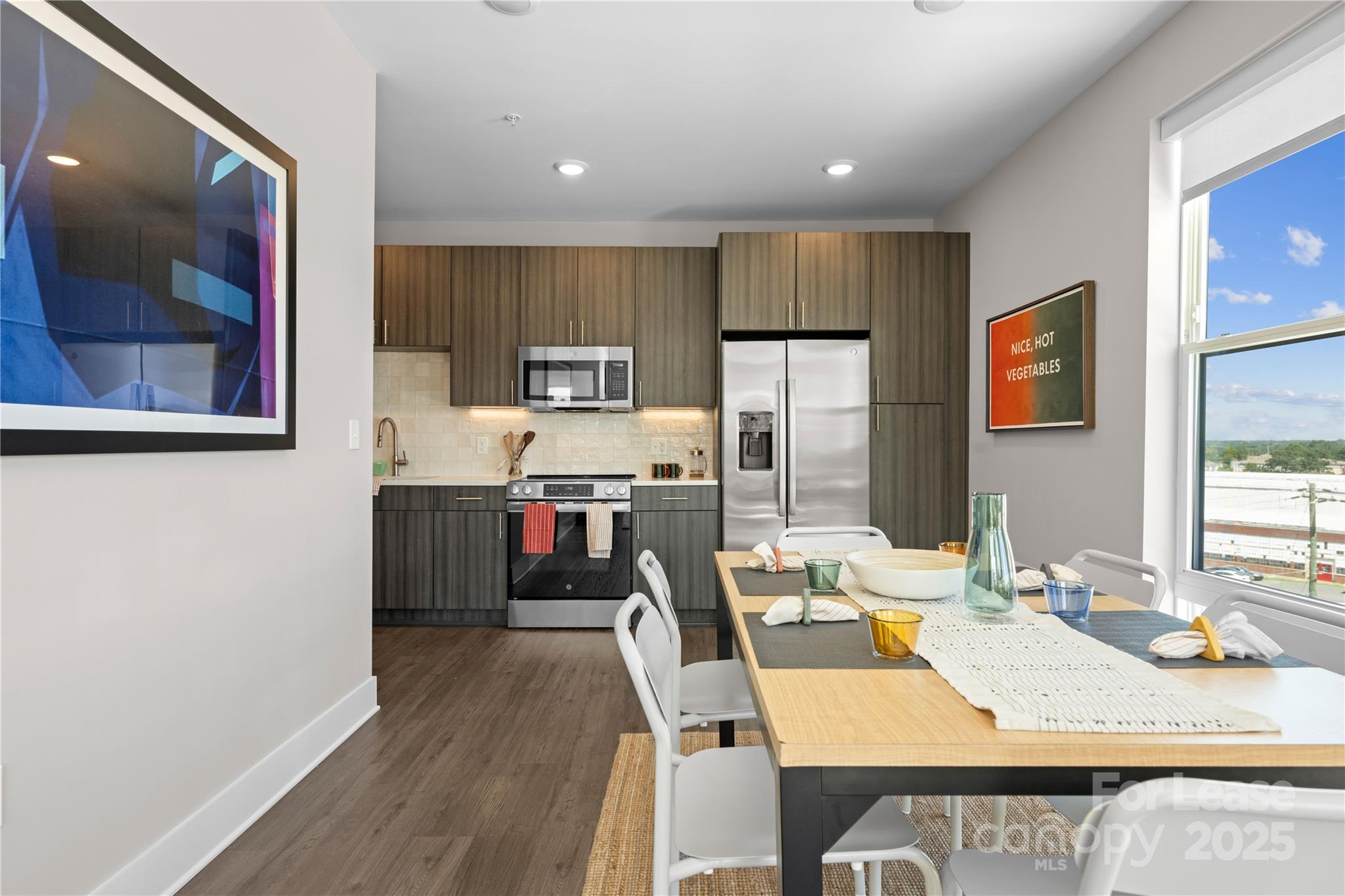 110 Razades Way, Unit A1 Charlotte, NC 28206 - Photo 24 of 29 a kitchen with kitchen island a appliances wooden floor and a dining table