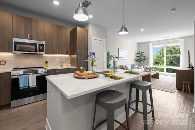 a kitchen with a stove a sink a kitchen island with a dining table and chairs