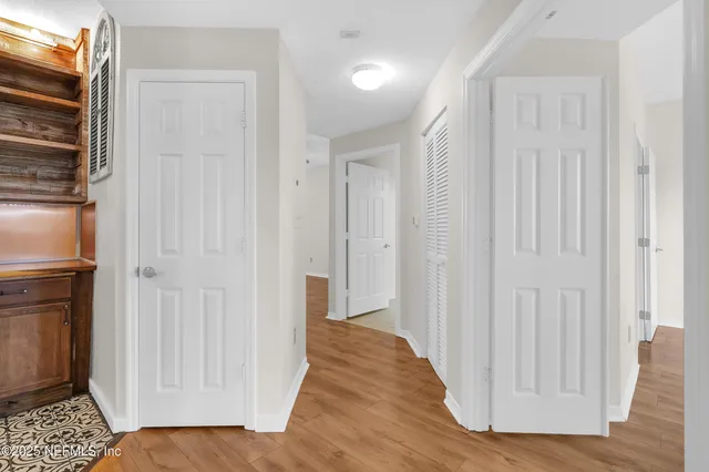 a view of a hallway with wooden floor and staircase