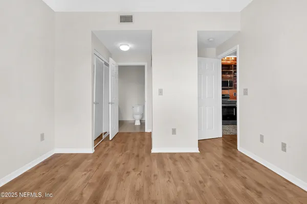 an empty room with wooden floor and closet
