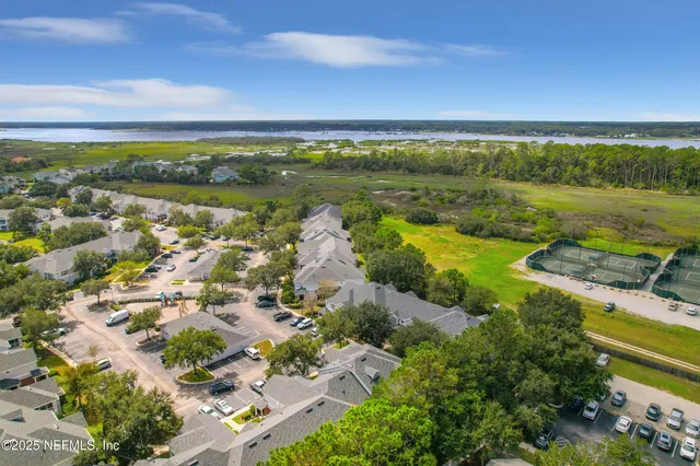 an aerial view of a city with lots of residential buildings ocean and mountain view in back