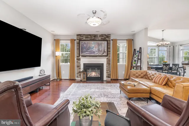 a kitchen with a stove a sink dishwasher a kitchen island with chairs and wooden cabinets