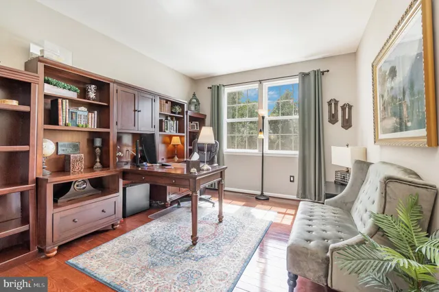 a living room with a flat screen tv a rug and a window