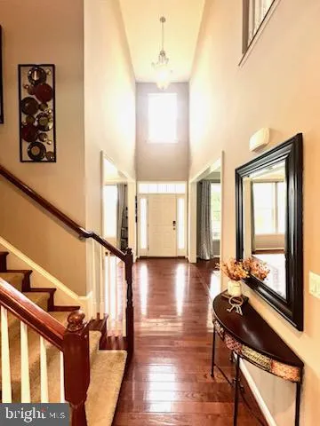 a view of a hallway with wooden floor and stairs