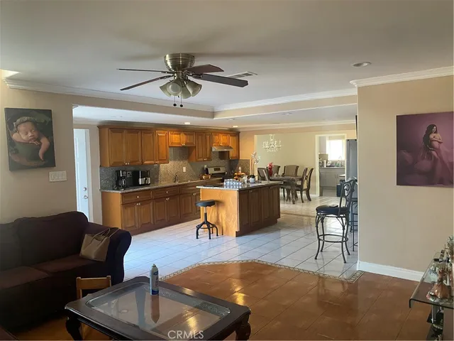 a living room with furniture kitchen view and a wooden floor