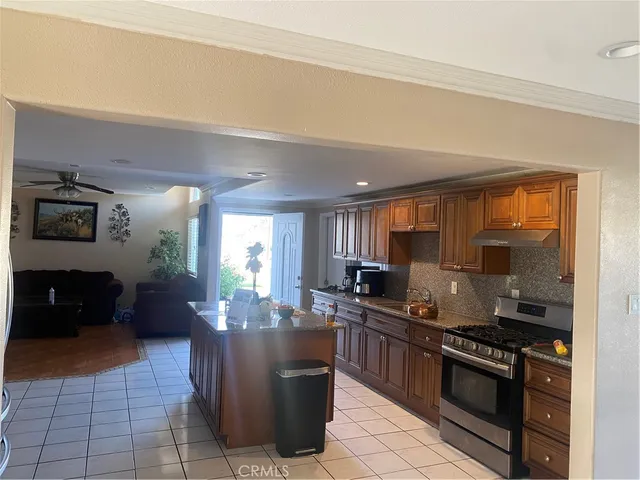 a kitchen with stainless steel appliances granite countertop a stove a sink and a refrigerator