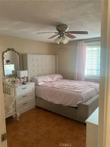 a spacious bedroom with a bed and a chandelier
