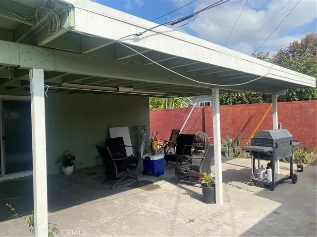 a view of patio with a table and chairs under an umbrella