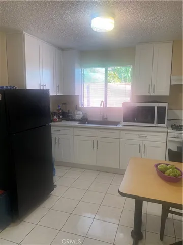 a kitchen with stainless steel appliances a sink a stove a refrigerator a counter top space and cabinets