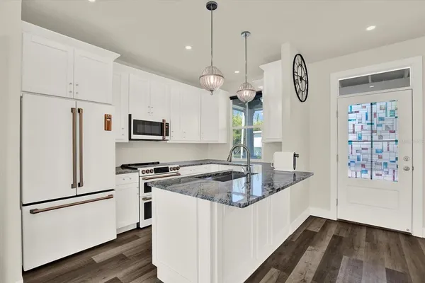 a kitchen that has a lot of cabinets and wooden floor