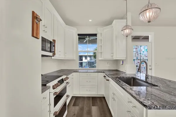 a view of kitchen with sink microwave and refrigerator