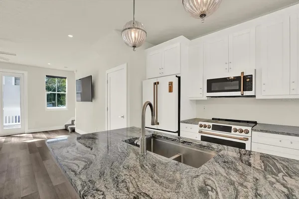 a large kitchen with stainless steel appliances granite countertop a stove and a refrigerator