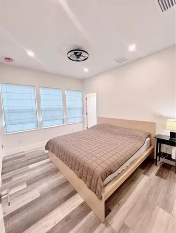 a bed sitting in a spacious bedroom next to a window