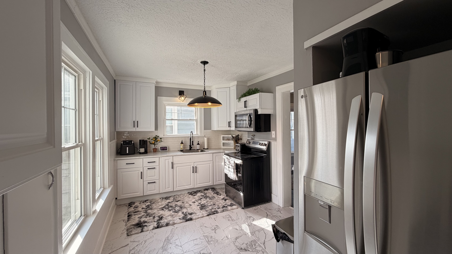 909 East 3rd Street Centralia, IL 62801 - Photo 7 of 25 a kitchen with white cabinets and stainless steel appliances