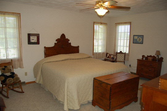 1771 East Town Line Road Oregon, IL 61061 - Photo 4 of 6 a bed room with a bed and a chandelier
