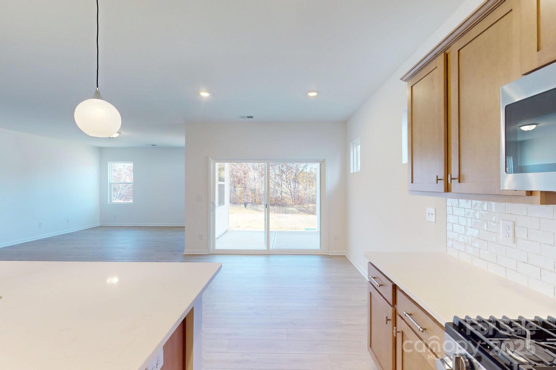 1494 Kate Cecil Way York, SC 29745 - Photo 8 of 20 a kitchen with granite countertop a sink a stove and a wooden floors