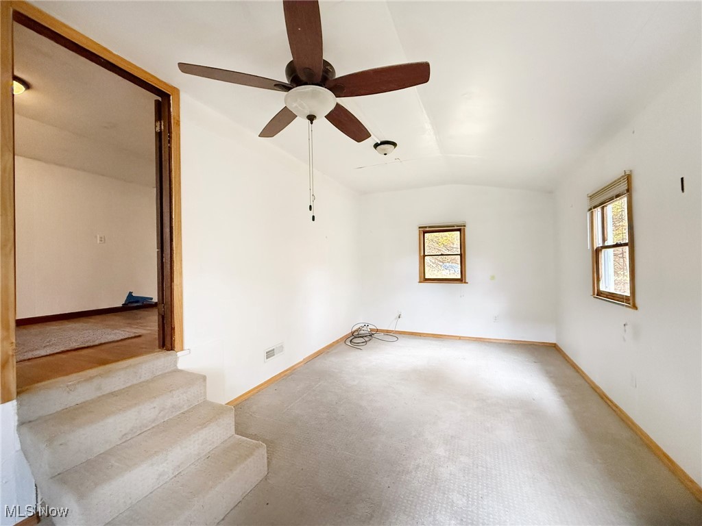 4589 Harmon Creek Road Colliers, WV 26035 - Photo 12 of 26 Carpeted empty room with plenty of natural light, vaulted ceiling, and a ceiling fan