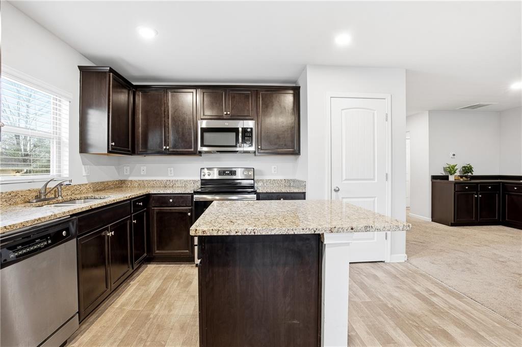 6968 New Dale Road Rex, GA 30273 - Photo 15 of 47 a large kitchen with granite countertop a sink and cabinets