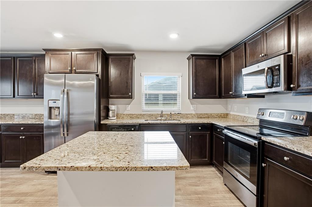 6968 New Dale Road Rex, GA 30273 - Photo 16 of 47 a kitchen with stainless steel appliances granite countertop a stove microwave and sink