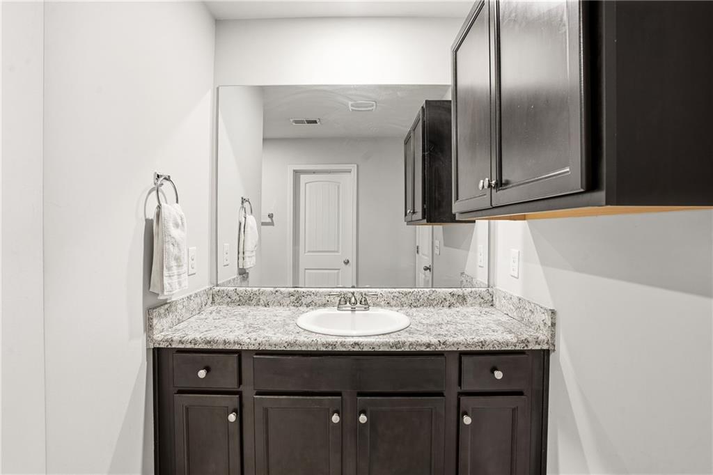 6968 New Dale Road Rex, GA 30273 - Photo 37 of 47 a bathroom with a granite countertop sink and a mirror