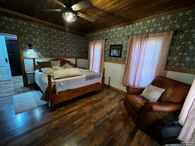 a spacious bedroom with a bed and wooden floor