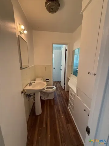 a bathroom with a sink a toilet a mirror and shower