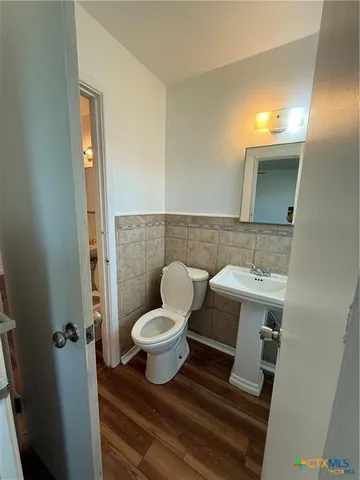 a bathroom with a toilet sink and mirror