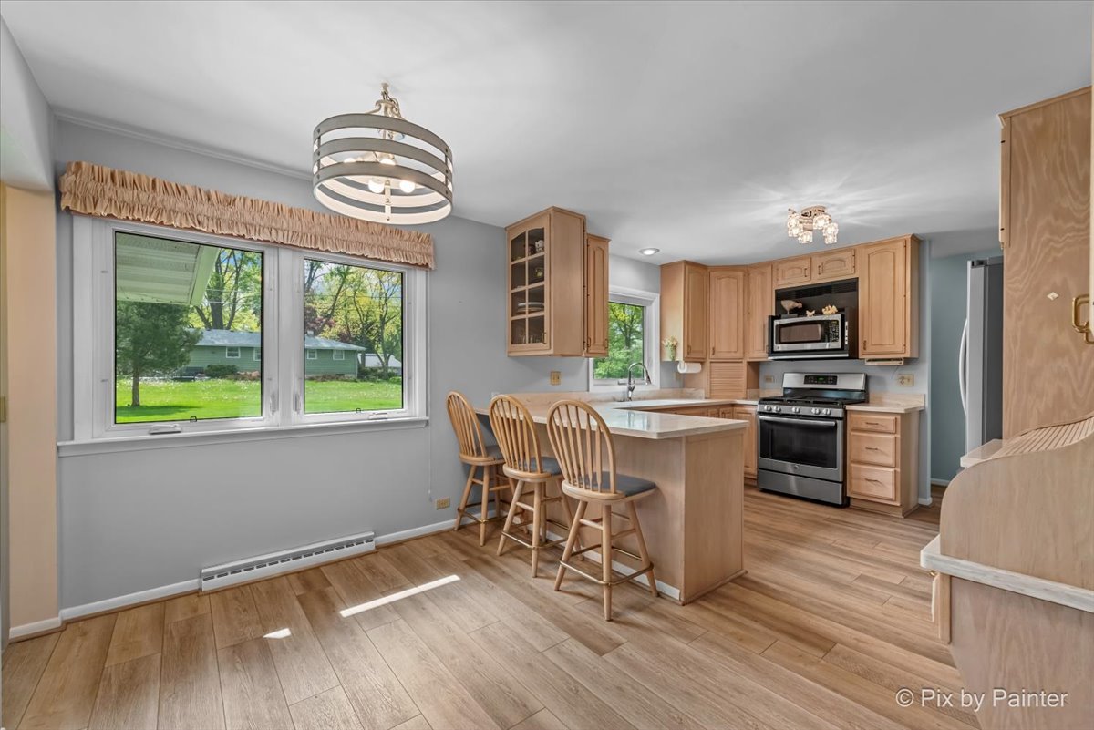 425 Summit Street Algonquin, IL 60102 - Photo 9 of 43 a kitchen with granite countertop a stove top oven cabinets a dining table and chairs