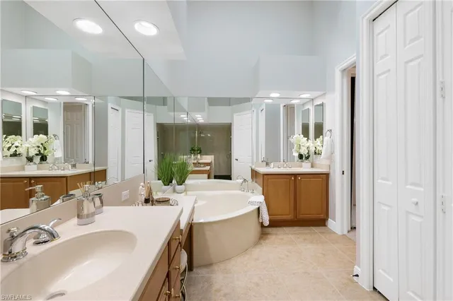 a bathroom with a double vanity sink mirror and bathtub