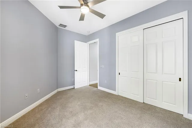 an empty room with a ceiling fan and a window