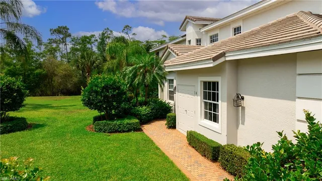 a view of a white house next to a yard