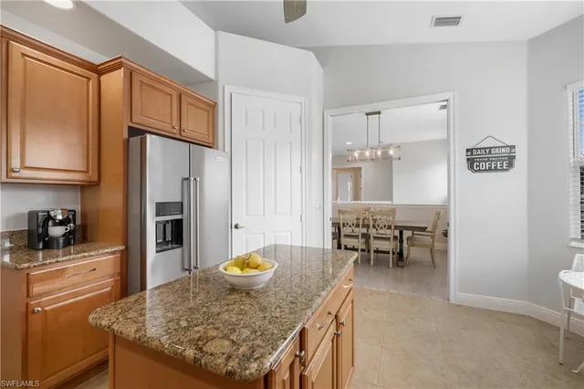 a kitchen with refrigerator and chairs