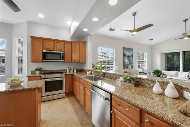 a kitchen with sink stove a microwave and cabinets