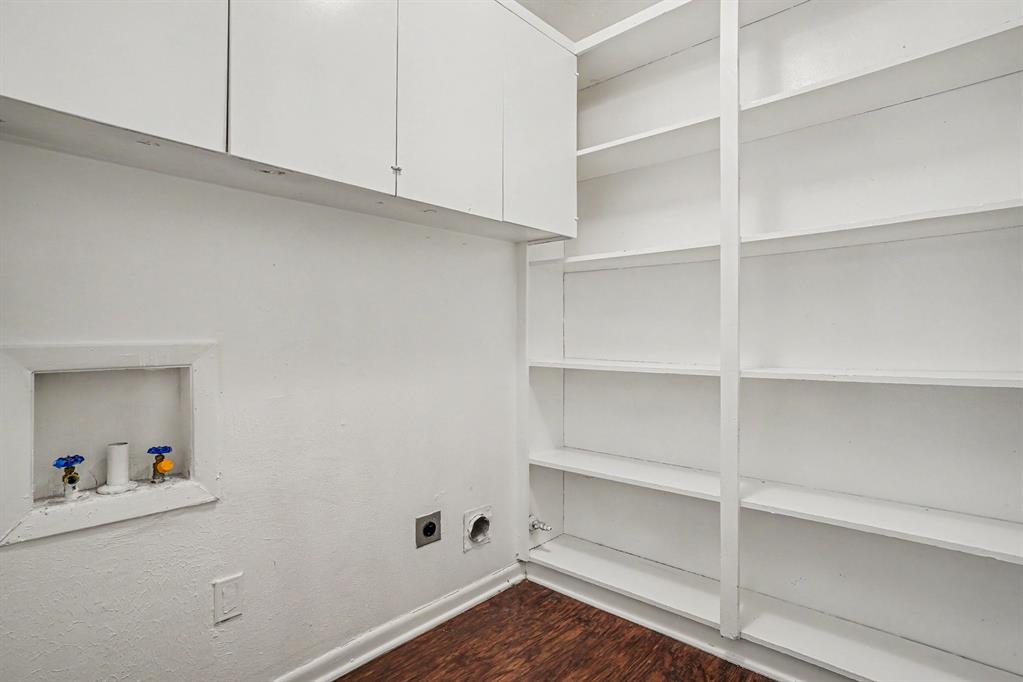 1414 Finley Road Irving, TX 75062 - Photo 12 of 27 White built-in cabinetry, extensive built-in shelving, wood-finish flooring, and laundry hookups