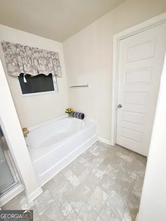 a bathroom with a bathtub and a shower