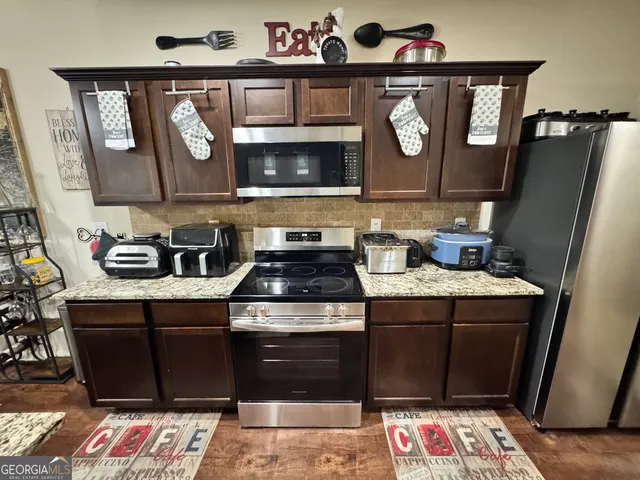 a kitchen with stainless steel appliances granite countertop a stove and a microwave
