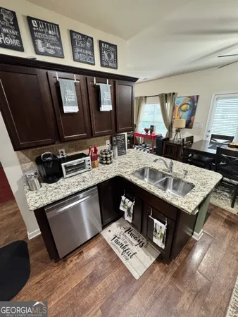 a kitchen with stainless steel appliances granite countertop a sink dishwasher stove and cabinets