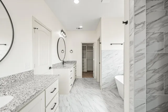 a spacious bathroom with a granite countertop sink a mirror and shower
