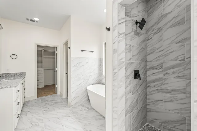 a bathroom with a granite countertop shower and a sink